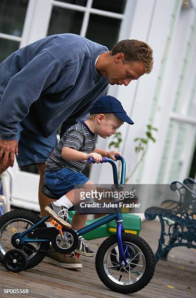 boy learning how to ride a bicycle - how fotografías e imágenes de stock