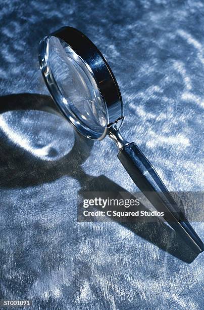 magnifying glass on blue background - blue glass stock pictures, royalty-free photos & images