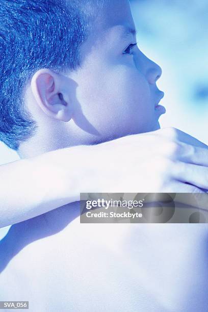 boy with his head turned to one side; adult's hand on his shoulder - dos humain photos et images de collection