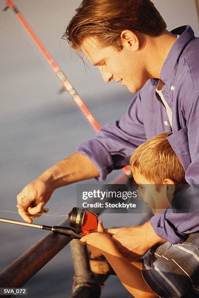 father and son fishing; son resting fishing pole against pier railing - gov scott visits miami school in zika cluster zone on first day of classes stockfoto's en -beelden