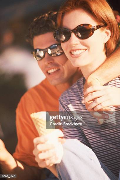man and woman eatign icecream together - gefrorene süßspeise stock-fotos und bilder