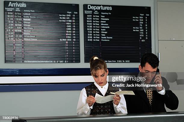 service representatives at airline desk - departure board front on fotografías e imágenes de stock