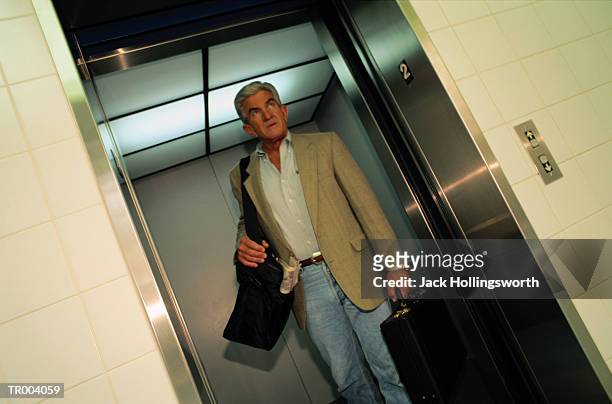 man coming out of elevator in airport - people coming of age purify with icy water in tokyo stockfoto's en -beelden