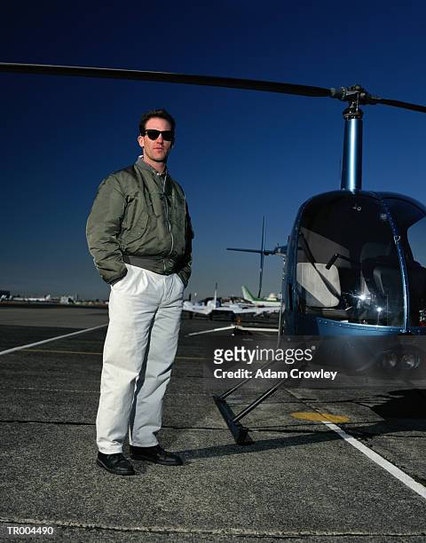 pilot standing next to helicopter - next stockfoto's en -beelden