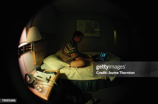 man with laptop in hotel room - thornton stock pictures, royalty-free photos & images