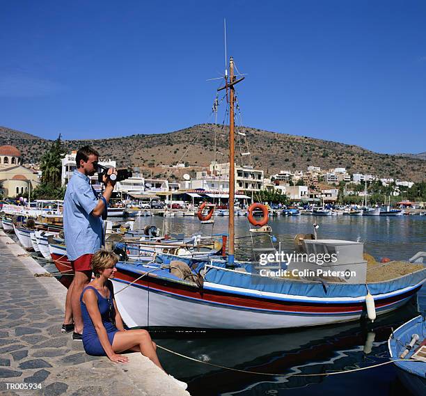 tourists at a harbor in crete - unveiling of life size statue of andrea bocelli at keep memory alive event center stockfoto's en -beelden