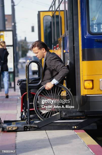 man in wheelchair exiting bus - city bus wheelchair stock pictures, royalty-free photos & images