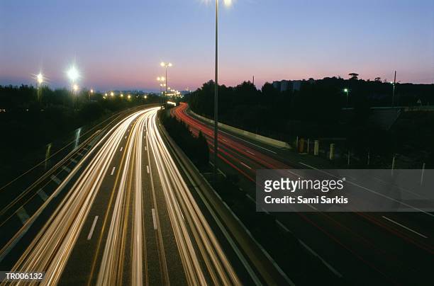 traffic at sunset - vehicle light fotografías e imágenes de stock