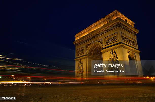 arc de triomphe at night - fahrzeuglicht stock-fotos und bilder