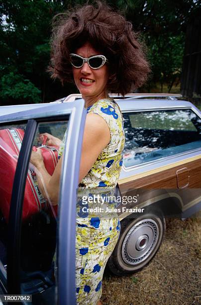 woman putting luggage in the car - alleen mid volwassen vrouwen stockfoto's en -beelden