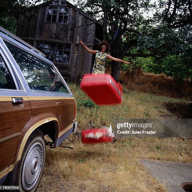 woman throwing luggage to car - miembro humano fotografías e imágenes de stock