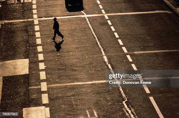 man walking across street - across stock pictures, royalty-free photos & images