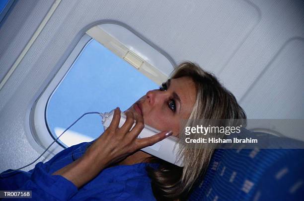 woman using airplane phone - only mid adult women stock pictures, royalty-free photos & images