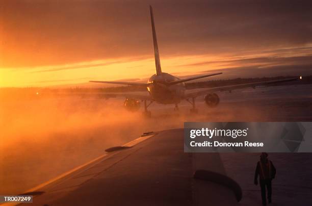 de-icing airplanes on the runway at dawn - reese stockfoto's en -beelden
