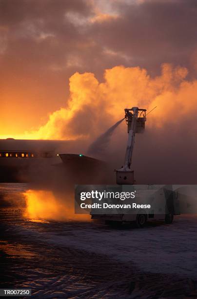 de-icing an airplane at dawn - de ices stock pictures, royalty-free photos & images