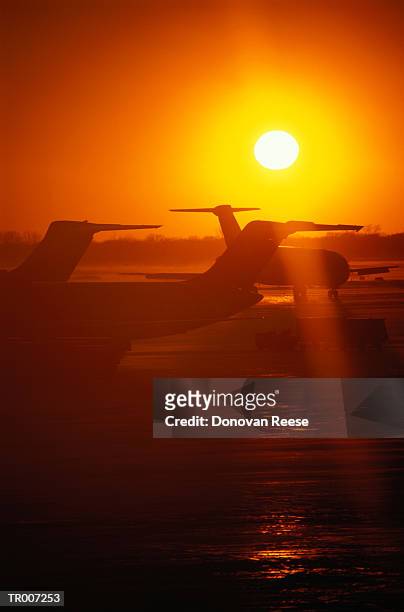 airplanes on a runway at sunrise - reese stockfoto's en -beelden