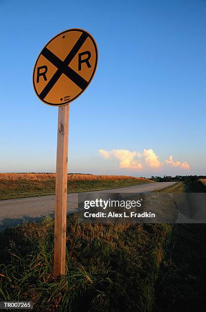 railroad  crossing sign by empty road - the cinema society with lands end host a screening of open road films mothers day after party stockfoto's en -beelden