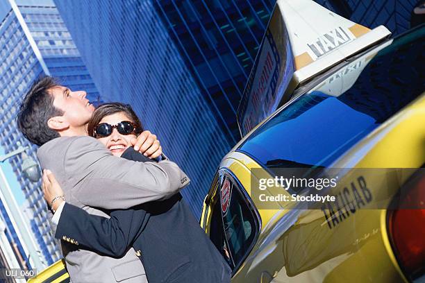 man and woman standing beside taxicab, hugging - personal land vehicle stock pictures, royalty-free photos & images