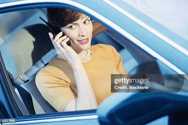 woman sitting in passenger side of car, talking on cellular phone - personal land vehicle stock pictures, royalty-free photos & images
