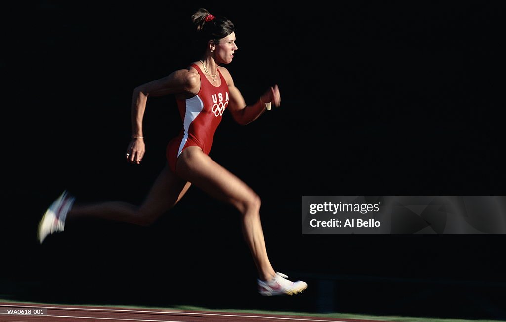 Female athlete running on track, close-up