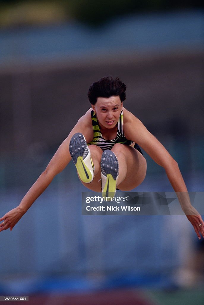 Female long jumper in mid-air, close-up