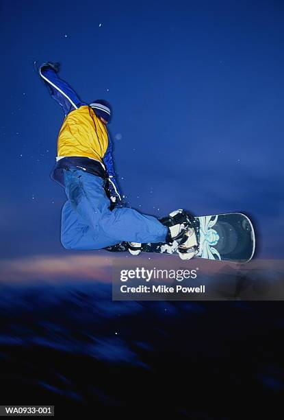 male snowboarder in mid-jump, close-up (blurred motion) - snowboard jump close up stock pictures, royalty-free photos & images