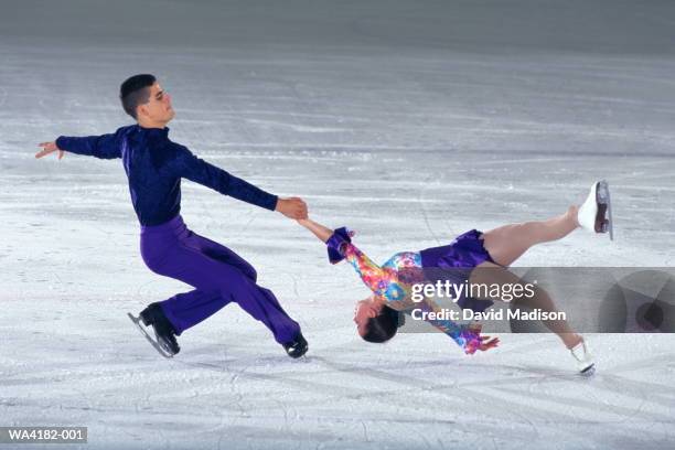 figure skating pairs, woman spinning in death spiral - death spiral stock pictures, royalty-free photos & images