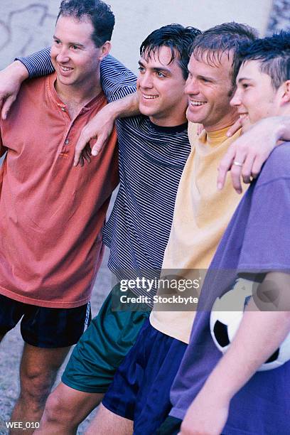 four men with arms around each other, smiling; one holding soccer ball - members of parliament address the nation following new zealand general election stockfoto's en -beelden