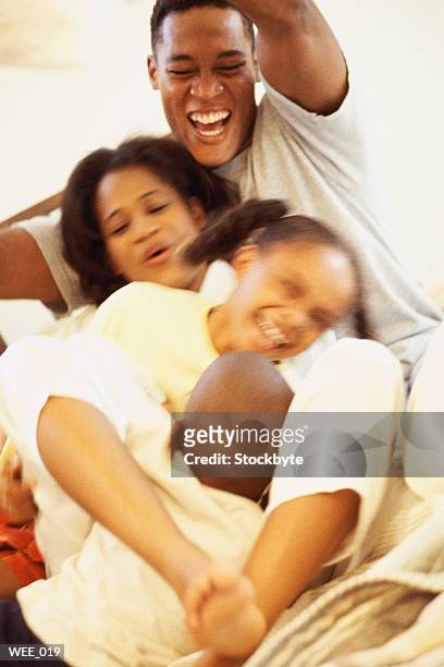 parents and children playing on bed - parents of michael brown return to missouri after speaking to united nations committee in switzerland stockfoto's en -beelden