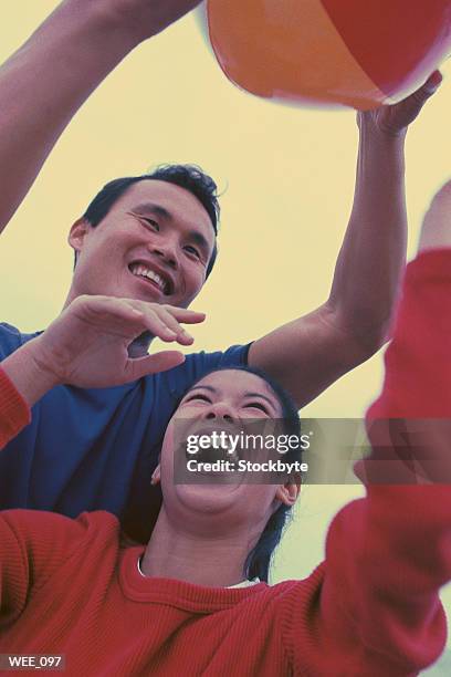 man and woman playing with beach ball - recreational equipment stock pictures, royalty-free photos & images