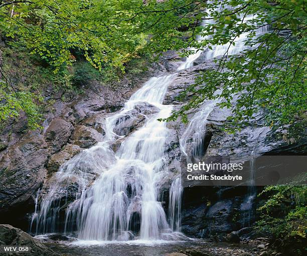 waterfall spilling into mountain pool - overhangend stockfoto's en -beelden