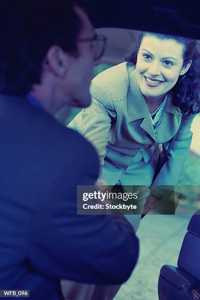 woman shaking hands with man sitting in car - personal land vehicle stock pictures, royalty-free photos & images