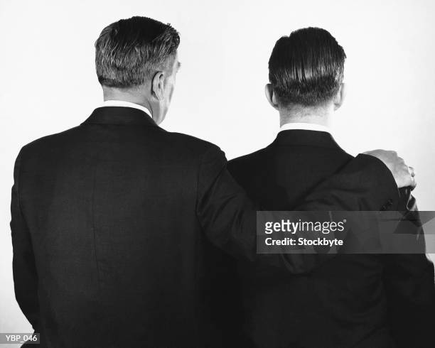 rückansicht von zwei männer, ein mit arm umlegen anderen - a of of stock-fotos und bilder