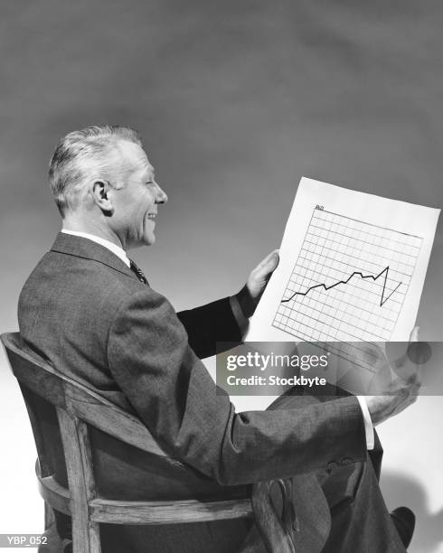 man looking at chart - alleen oudere mannen stockfoto's en -beelden