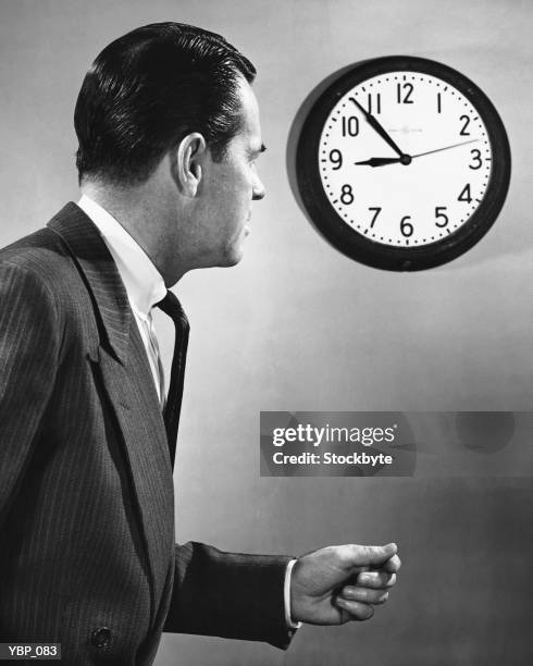 hombre mirando el reloj - at fotografías e imágenes de stock