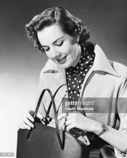 woman looking into purse - alleen mid volwassen vrouwen stockfoto's en -beelden