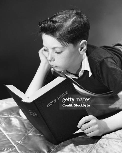 boy reading bible - holy book stock pictures, royalty-free photos & images