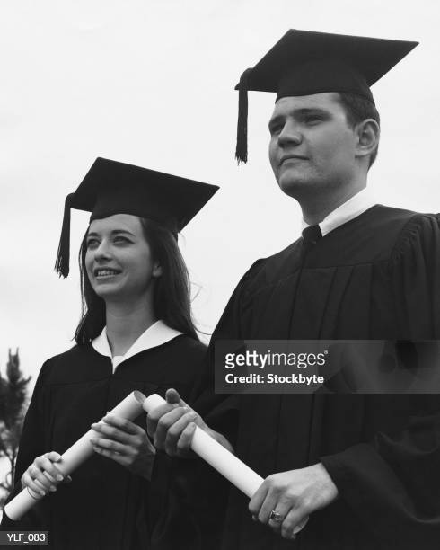 man and woman in graduation caps and gowns - academy of motion picture arts sciences oscar night celebration stockfoto's en -beelden