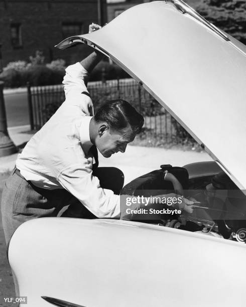 man looking under hood of car - a of stockfoto's en -beelden