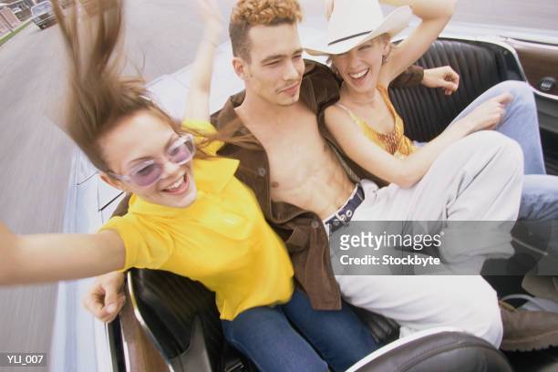 man and two women in back seat of convertible - a of of of stock-fotos und bilder