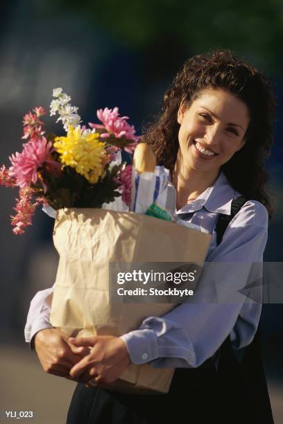 woman holding grocery bag with flowers - only mid adult women stock pictures, royalty-free photos & images