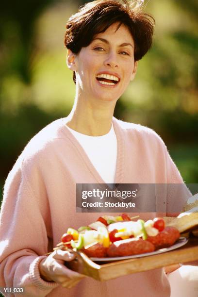 woman holding platter of shish kebabs - a of of imagens e fotografias de stock