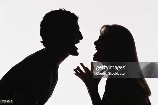 silhouette of man and woman yelling at each other - of stockfoto's en -beelden