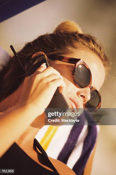 woman talking on cellular phone and suntanning - cruzeiro v cerro porteno copa bridgestone libertadores 2014 round of 16 stockfoto's en -beelden