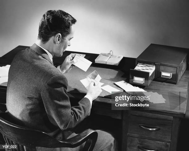 back view of man sitting and looking at address cards - only mature men stock pictures, royalty-free photos & images