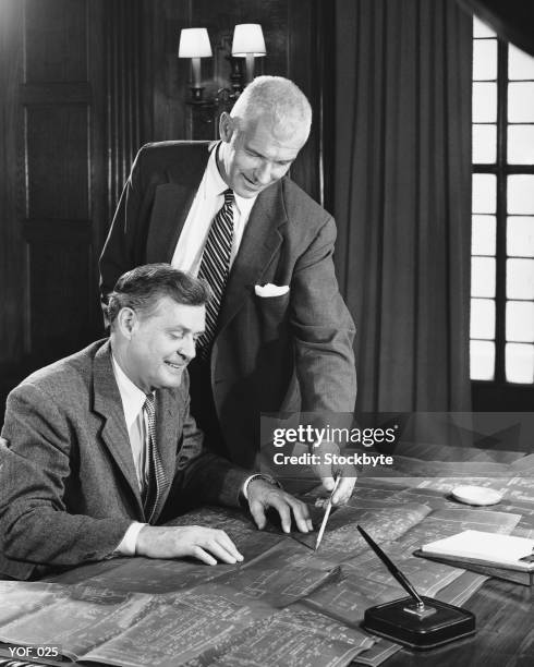 two men looking at blueprints - alleen oudere mannen stockfoto's en -beelden