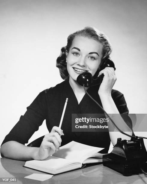 mujer utilizando el teléfono y lápiz de retención - instrumento de escribir fotografías e imágenes de stock