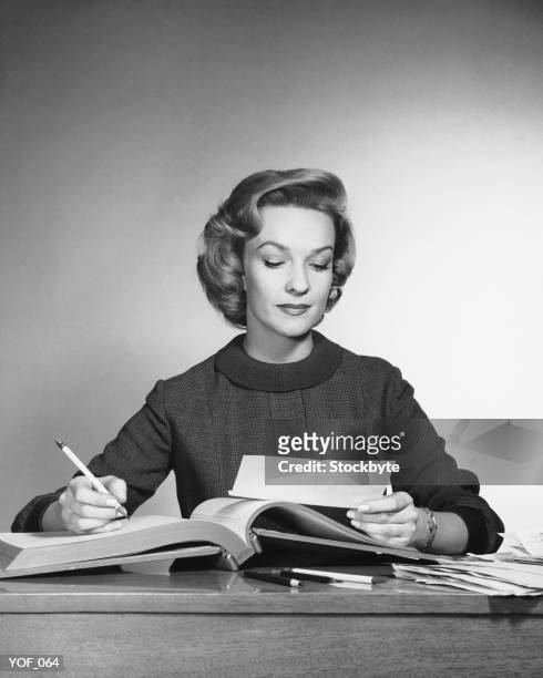 woman looking at paper, holding pencil - 1950 woman bildbanksfoton och bilder