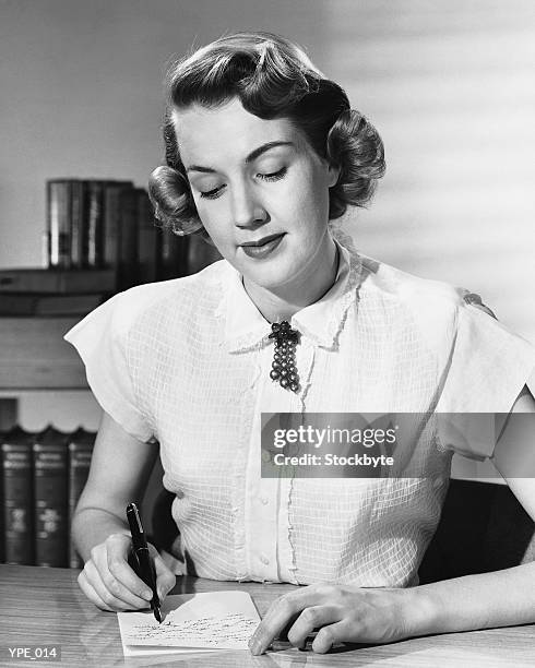mujer sentada en la recepción, escribir nota - at fotografías e imágenes de stock