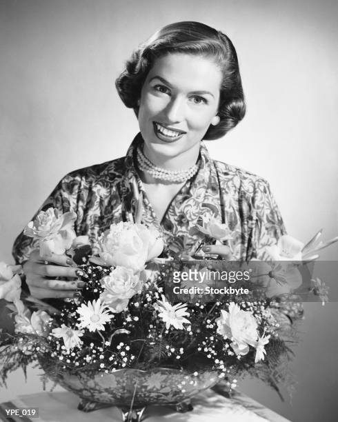 woman arranging flowers - alleen mid volwassen vrouwen stockfoto's en -beelden
